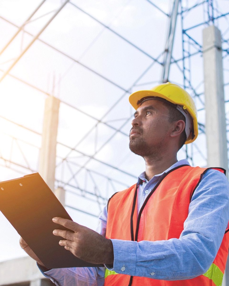 construction man holding clipboard looking up