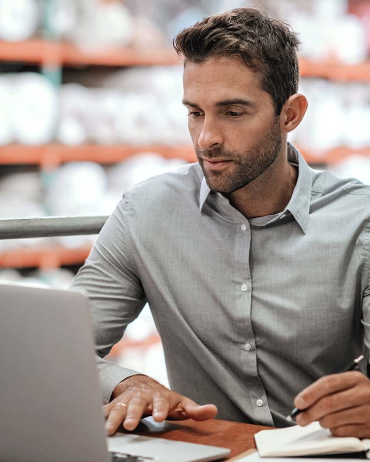 Man working on laptop in warehouse