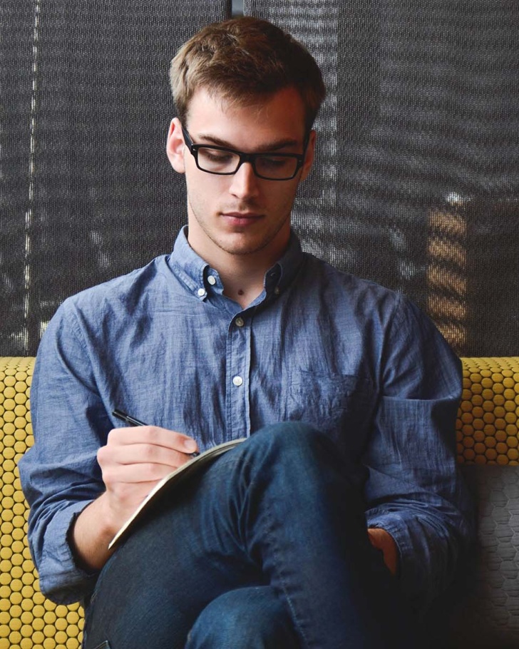 Man with glasses looking at paper intently