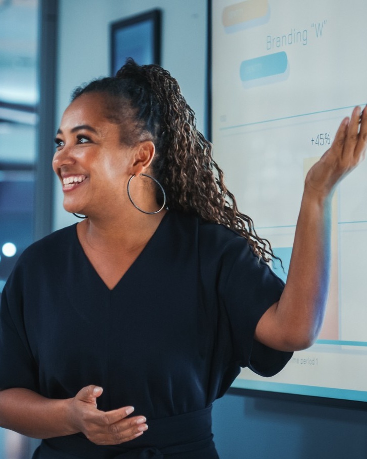 Blogheader image - B2B e-commerce KPIS - Woman presenting analytics in meeting - Sana Commerce blog