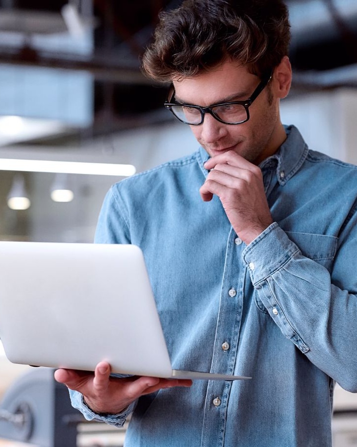 Man works on a laptop in an industrial building