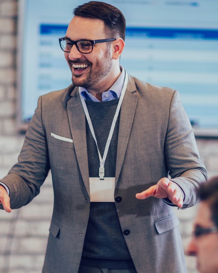 Man gestures with his hands amongst his colleagues