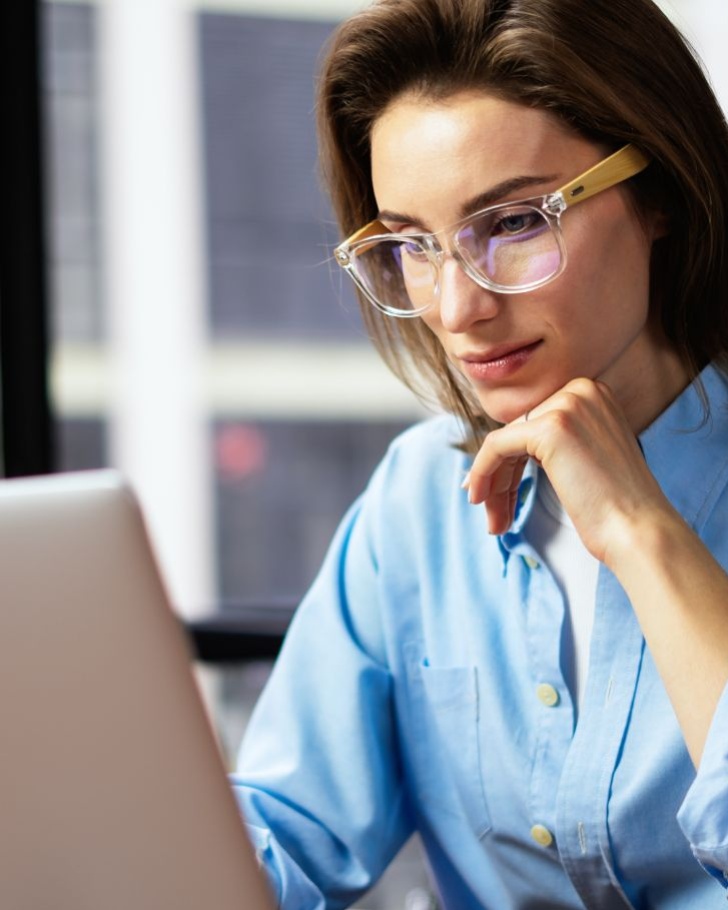 Woman wearing glasses working on her laptop