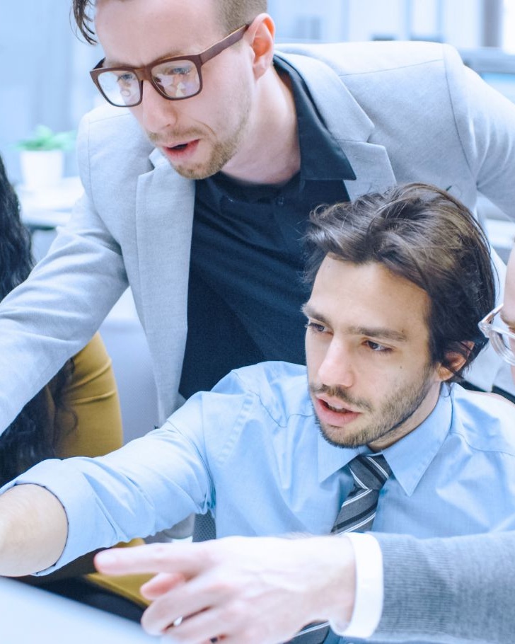 A group of colleagues point to their computer