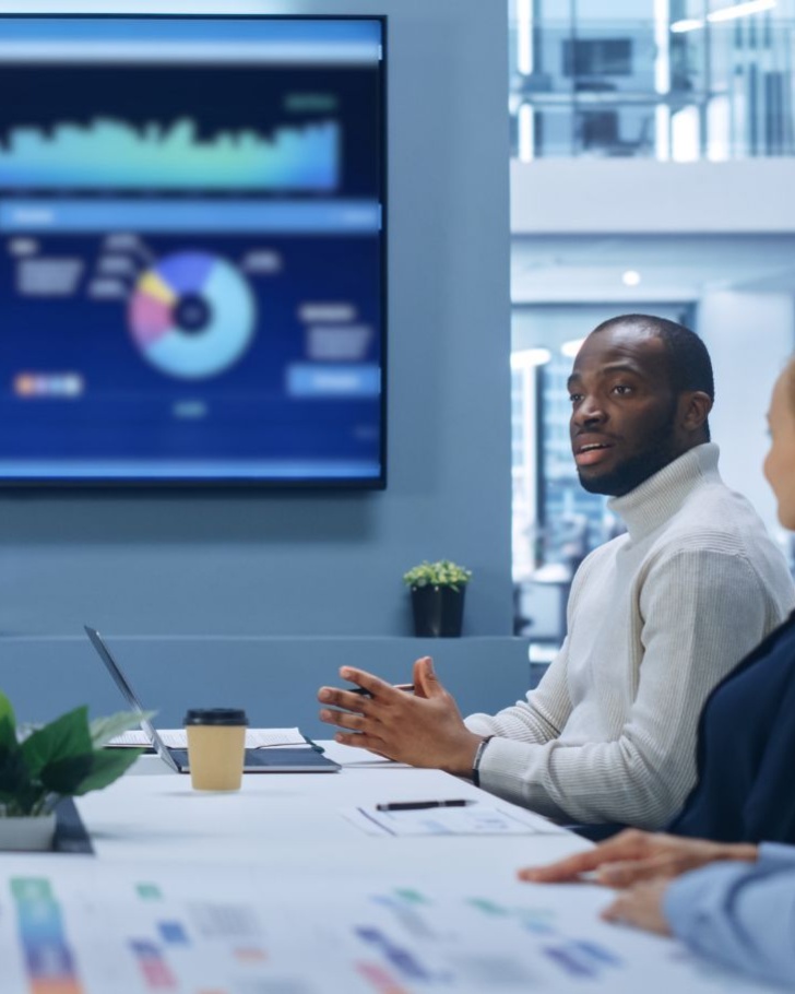 Co-workers gather around a conference table to discuss data