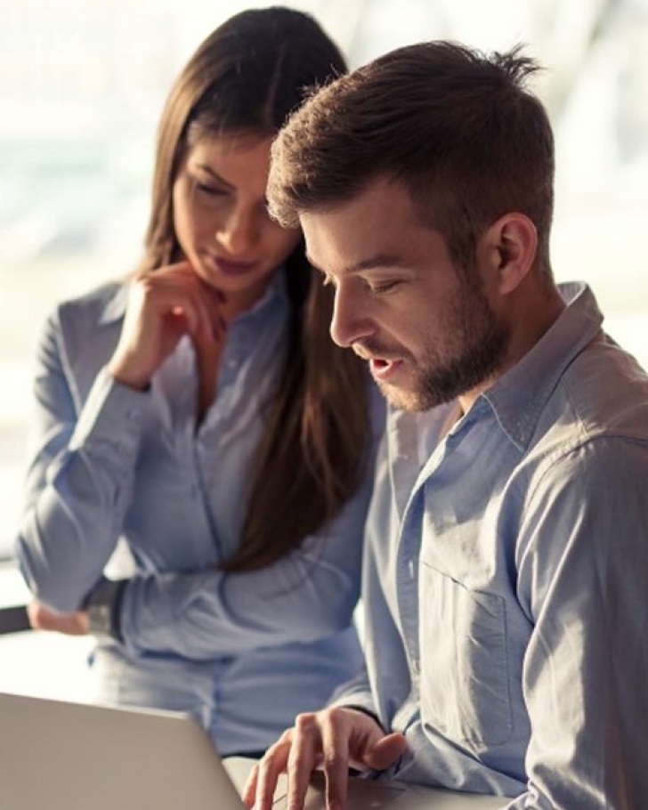 Two people working on a laptop.