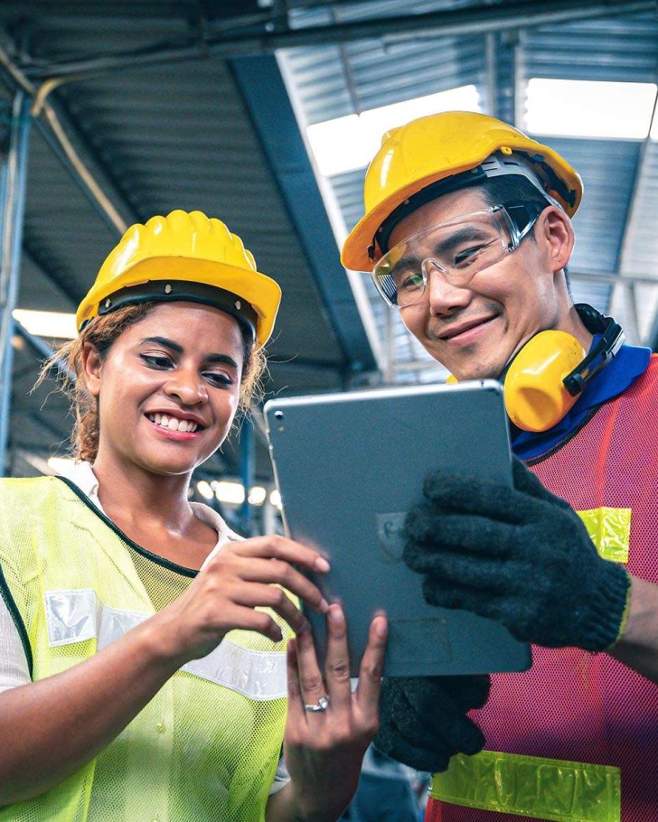 Two employees looking at a the benefits of a manufacturing e-commerce solution