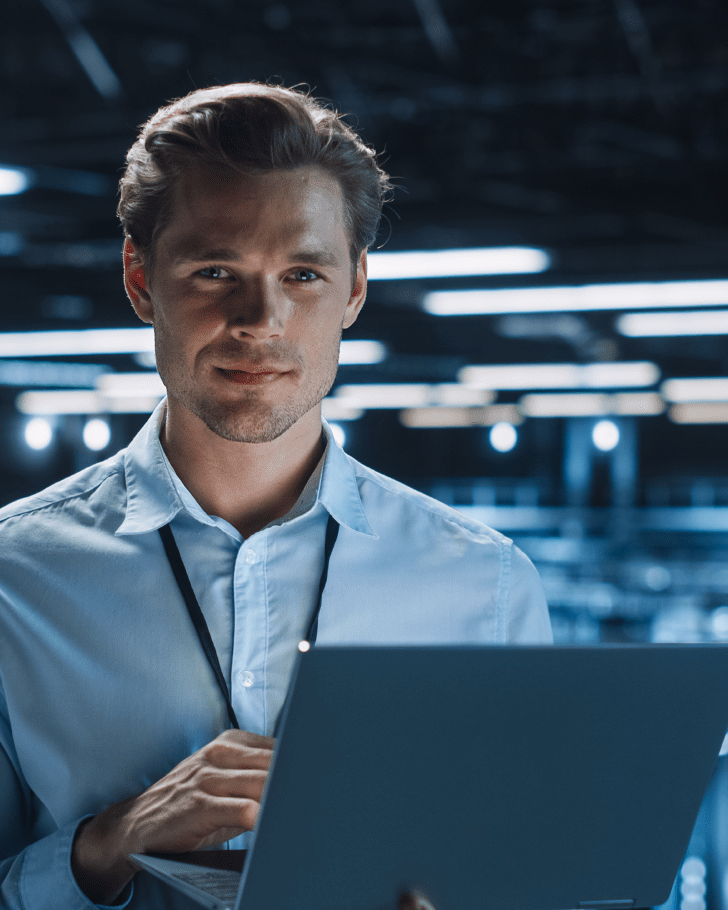 man holding laptop looking at camera