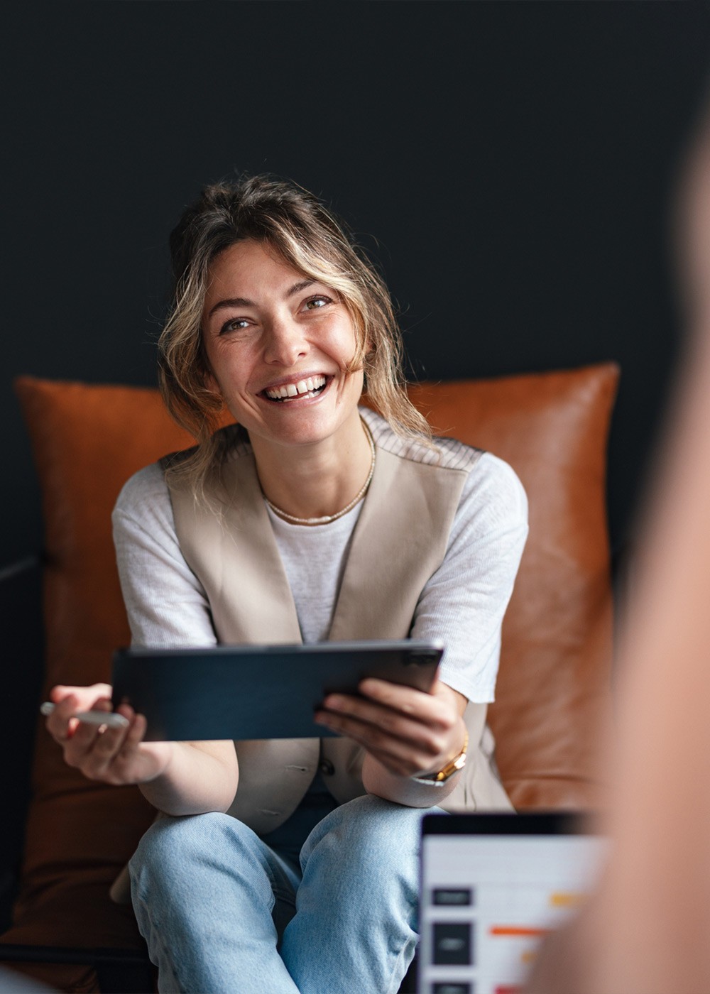 Woman Engaged in Team Discussion with Digital Tablet