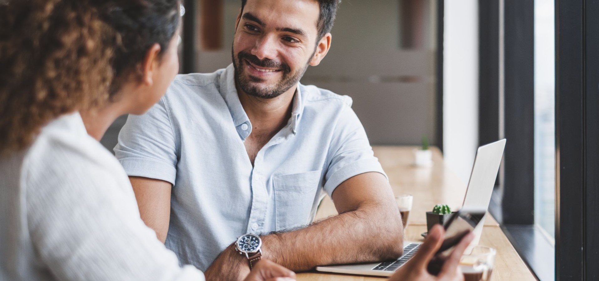 Two colleagues having a discussion by their laptop