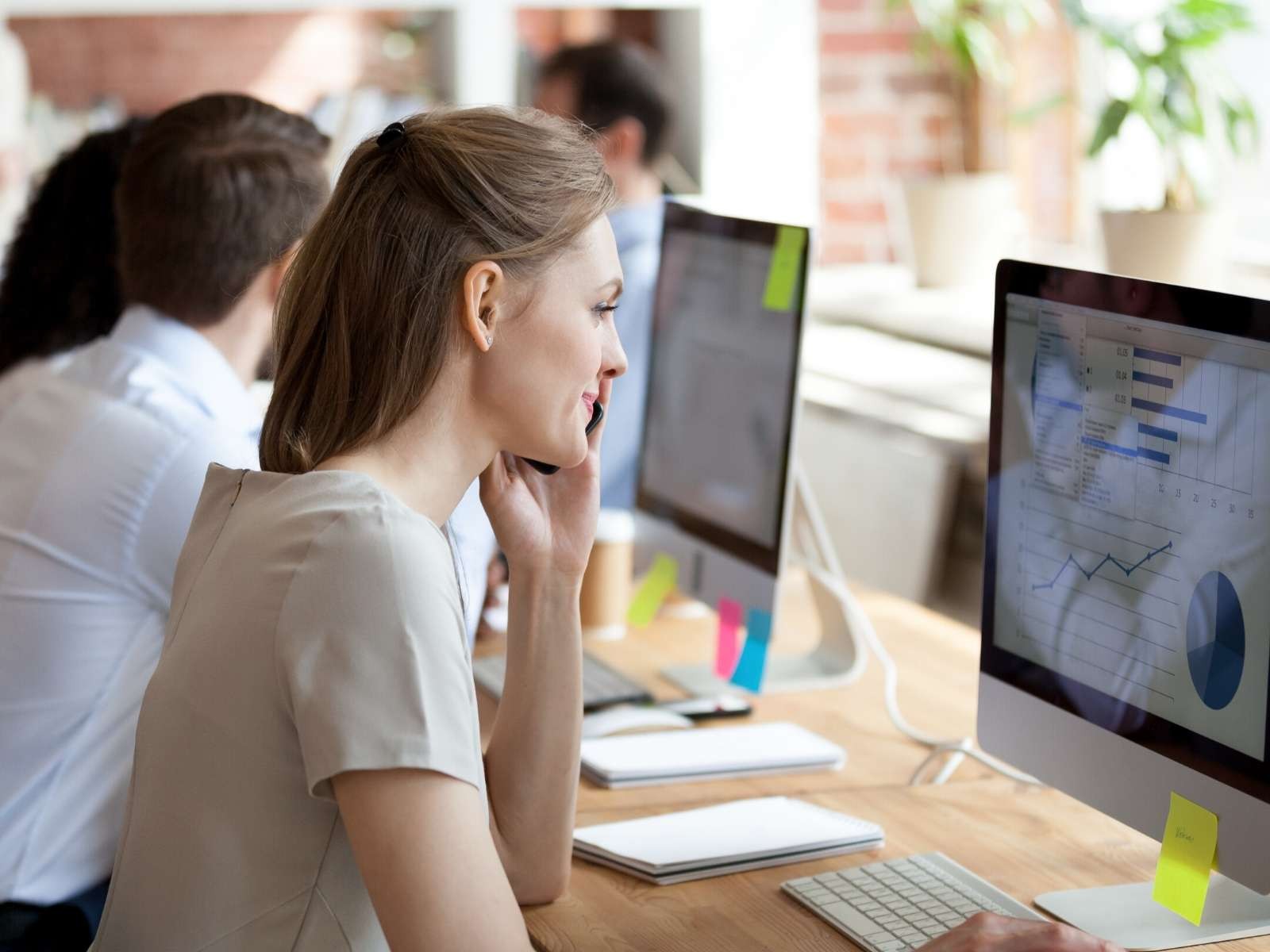 Woman-analyzing-graphs-and-figures-with-marketing-team