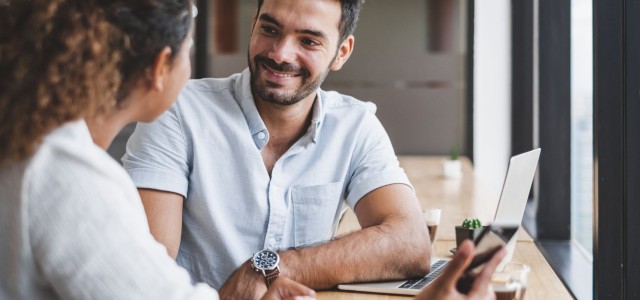 Two colleagues having a discussion by their laptop