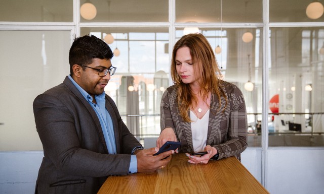 Two workers comparing information - The benefits of e-commerce for the manufacturing industry