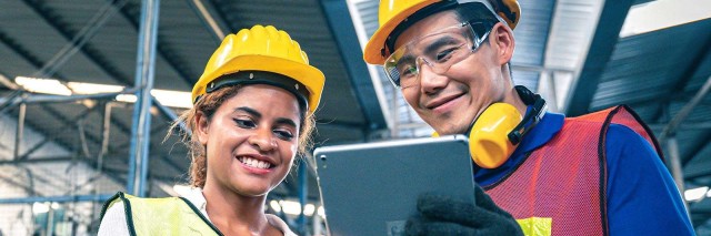 Two employees looking at a the benefits of a manufacturing e-commerce solution
