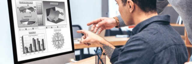 Two colleagues discuss work over computer