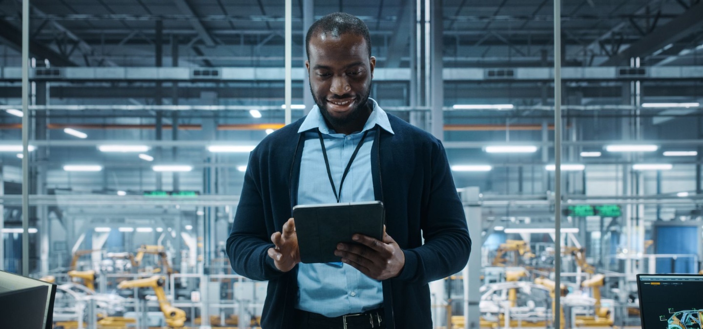 Professional in an industrial setting reviewing data on a tablet — representing the role of digital tools in an effective B2B content strategy