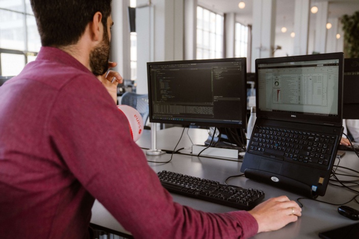 Man working on two computers