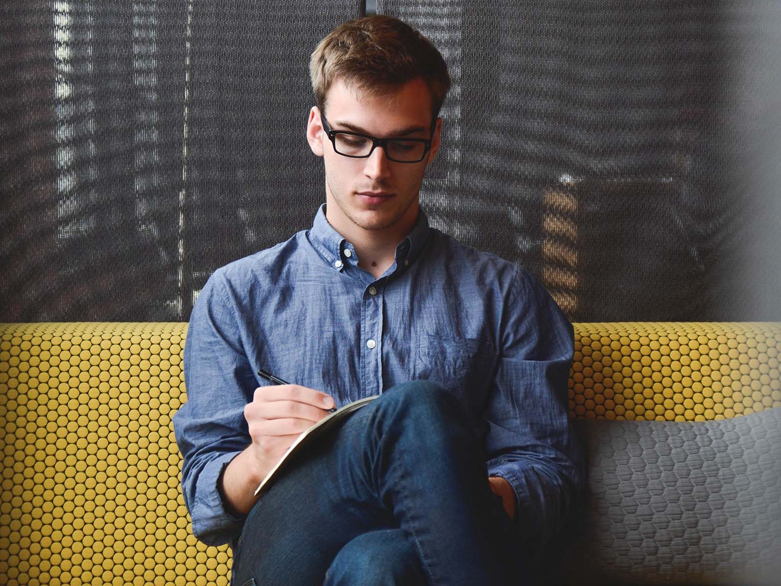 Man with glasses looking at paper intently