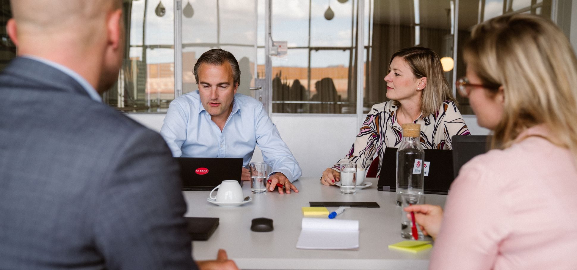 Colleagues discuss work in a conference room