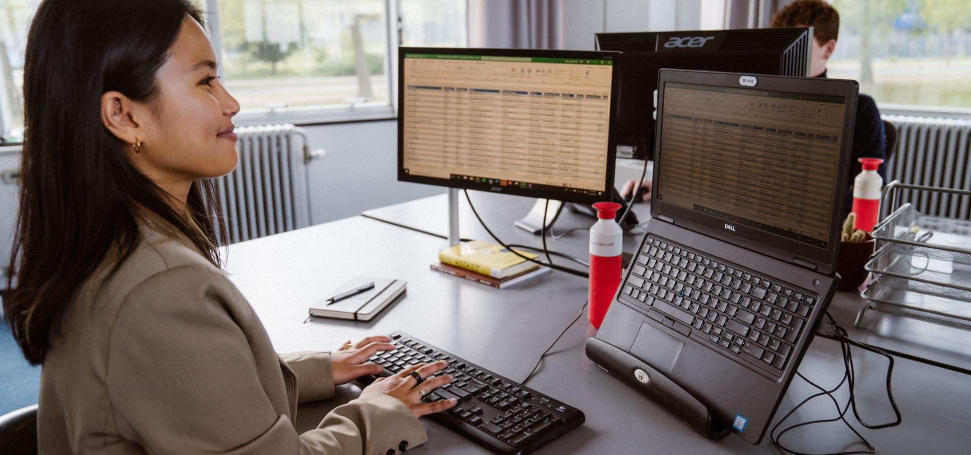 Woman examining research on two computers