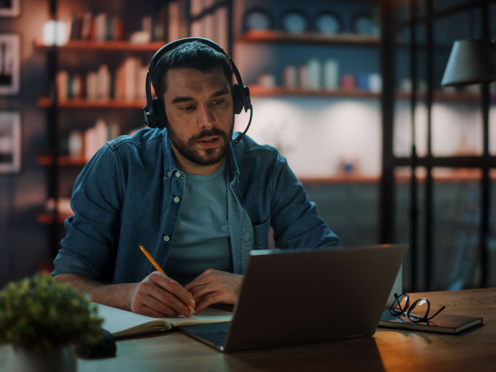 Man writing product descriptions with headphones on
