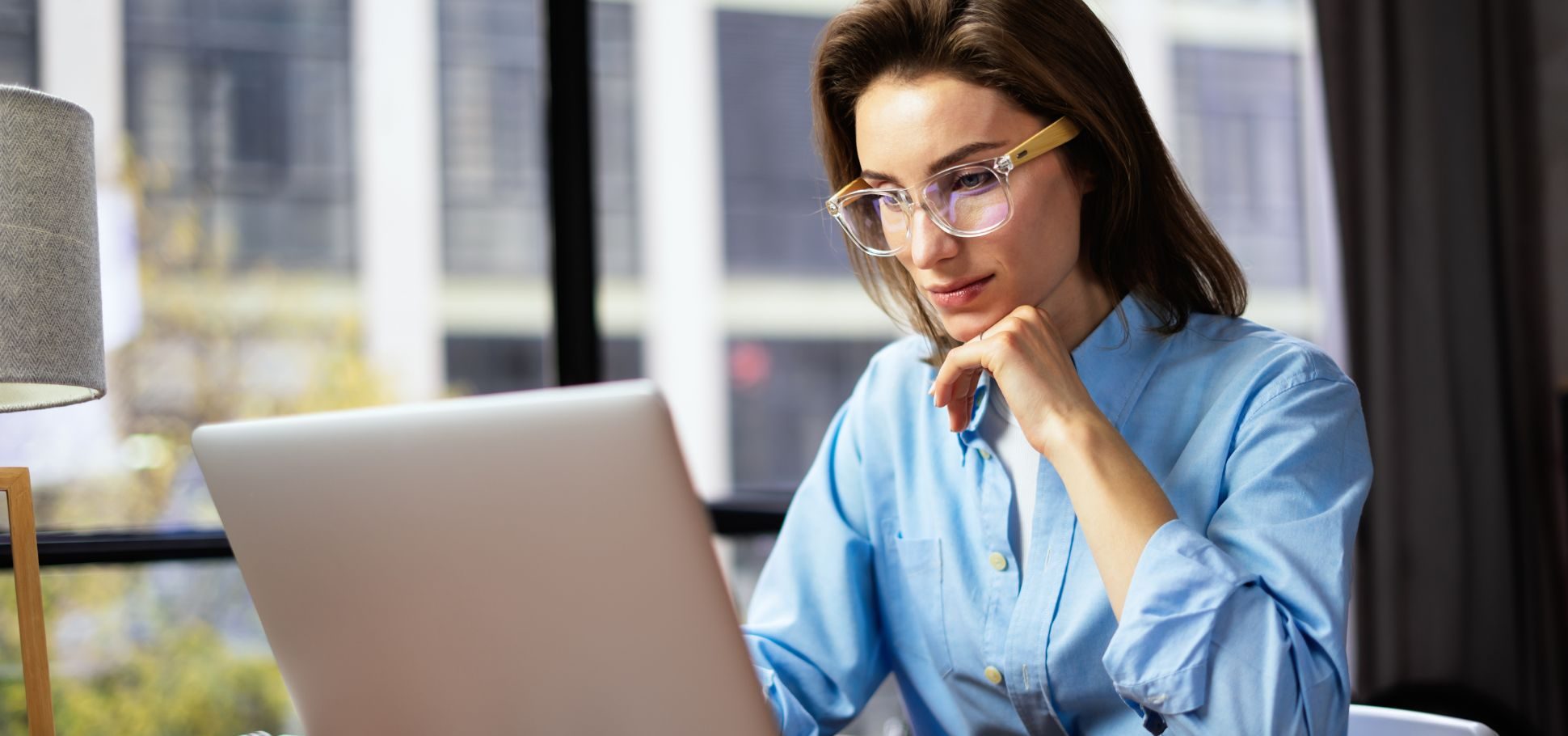 Woman wearing glasses working on her laptop