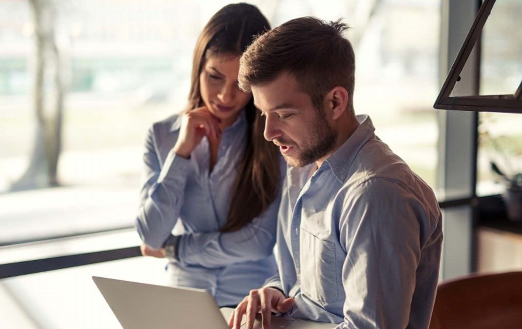 Two people working on a laptop.