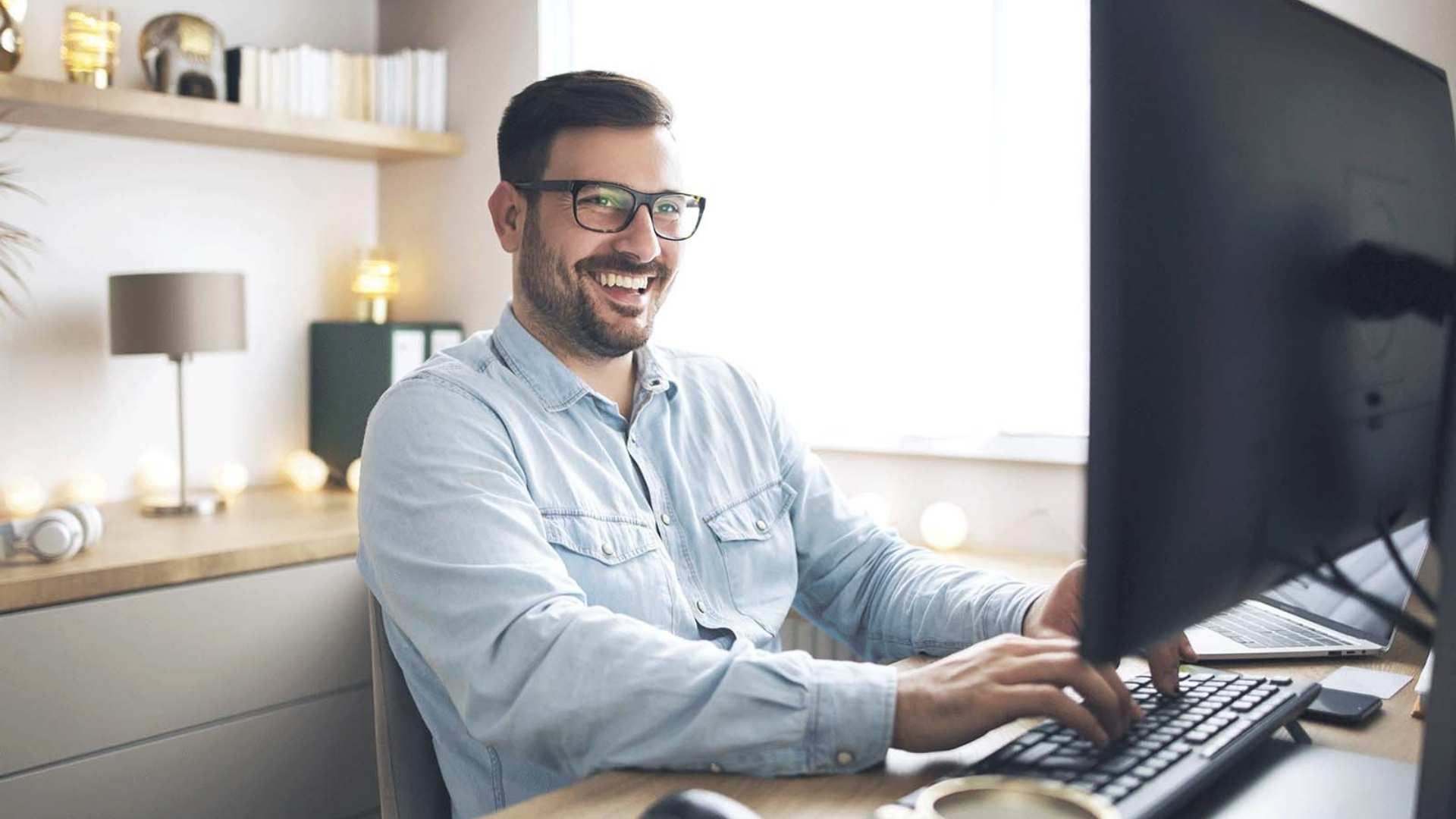 Featured image for B2B E-Commerce Startup Package - Smiling man learning something new on the computer