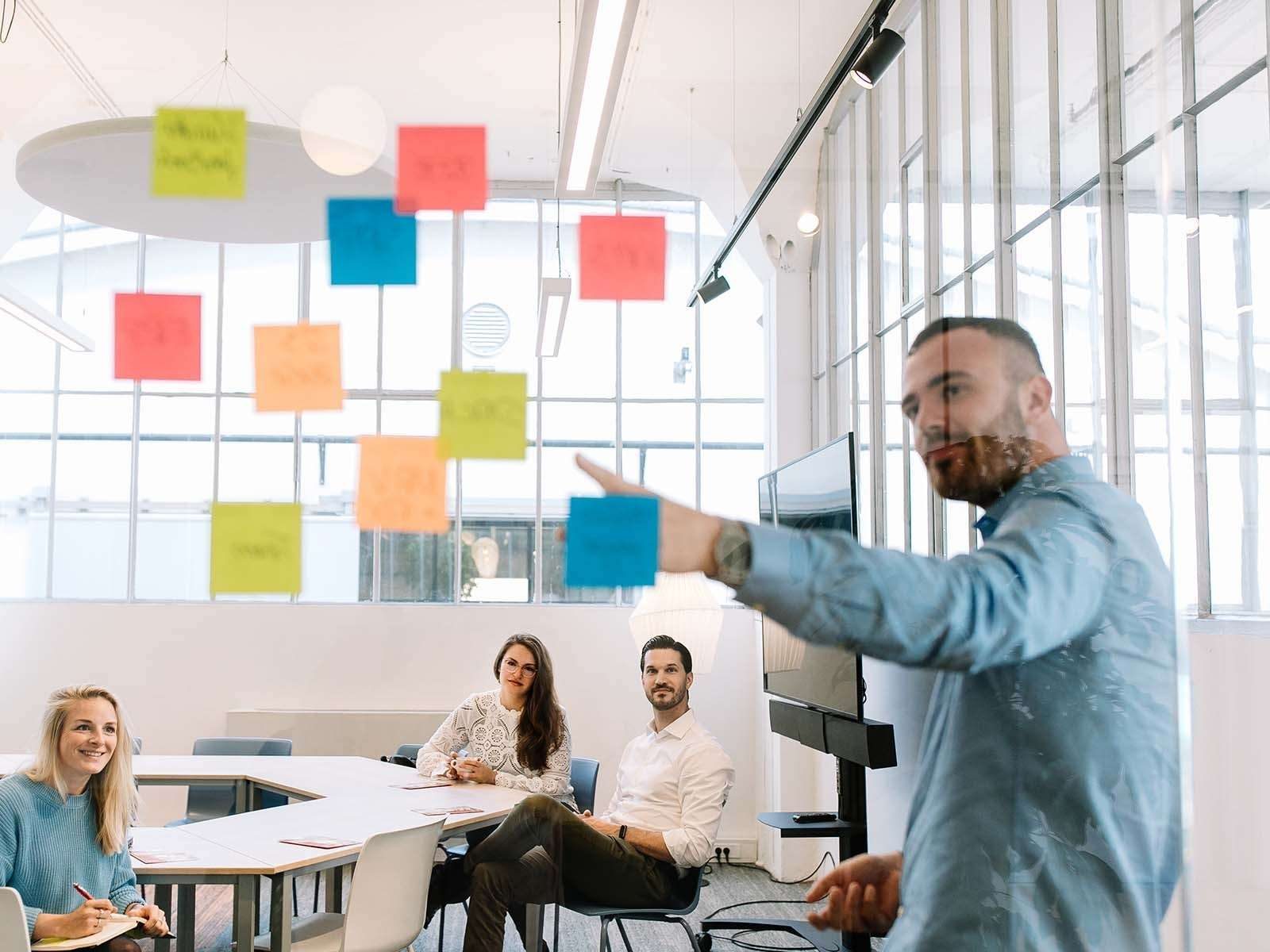 Man showing Lookbook concept to two coworkers