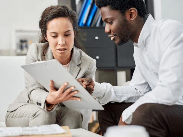 a man and a woman review information on a tablet