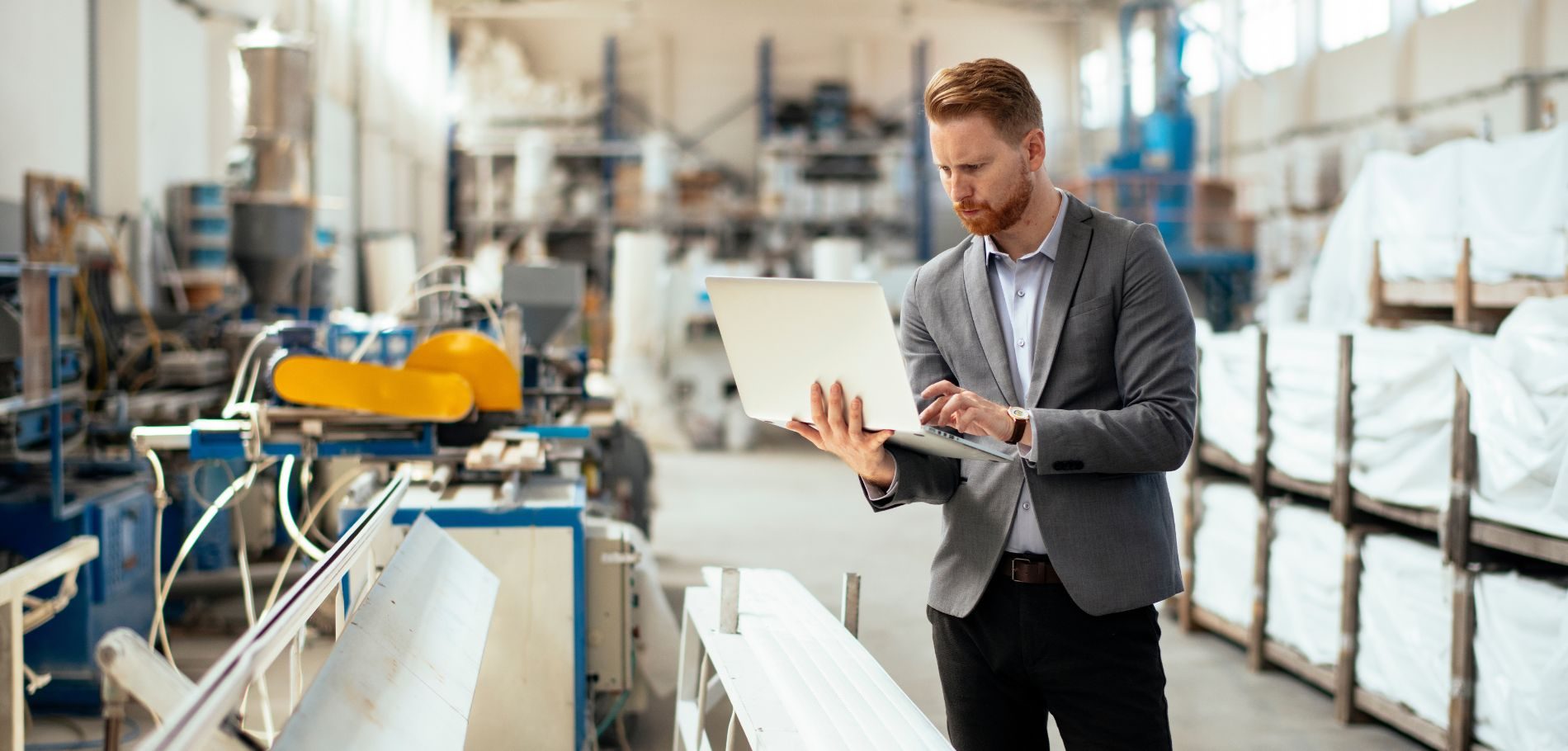 Employee working on laptop in factory