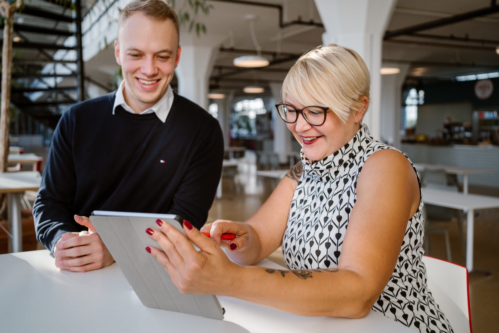 Melanie zeigt Dominik auf Laptop Maßnahmen zur Kundenbindung inklusive Mobile Commerce