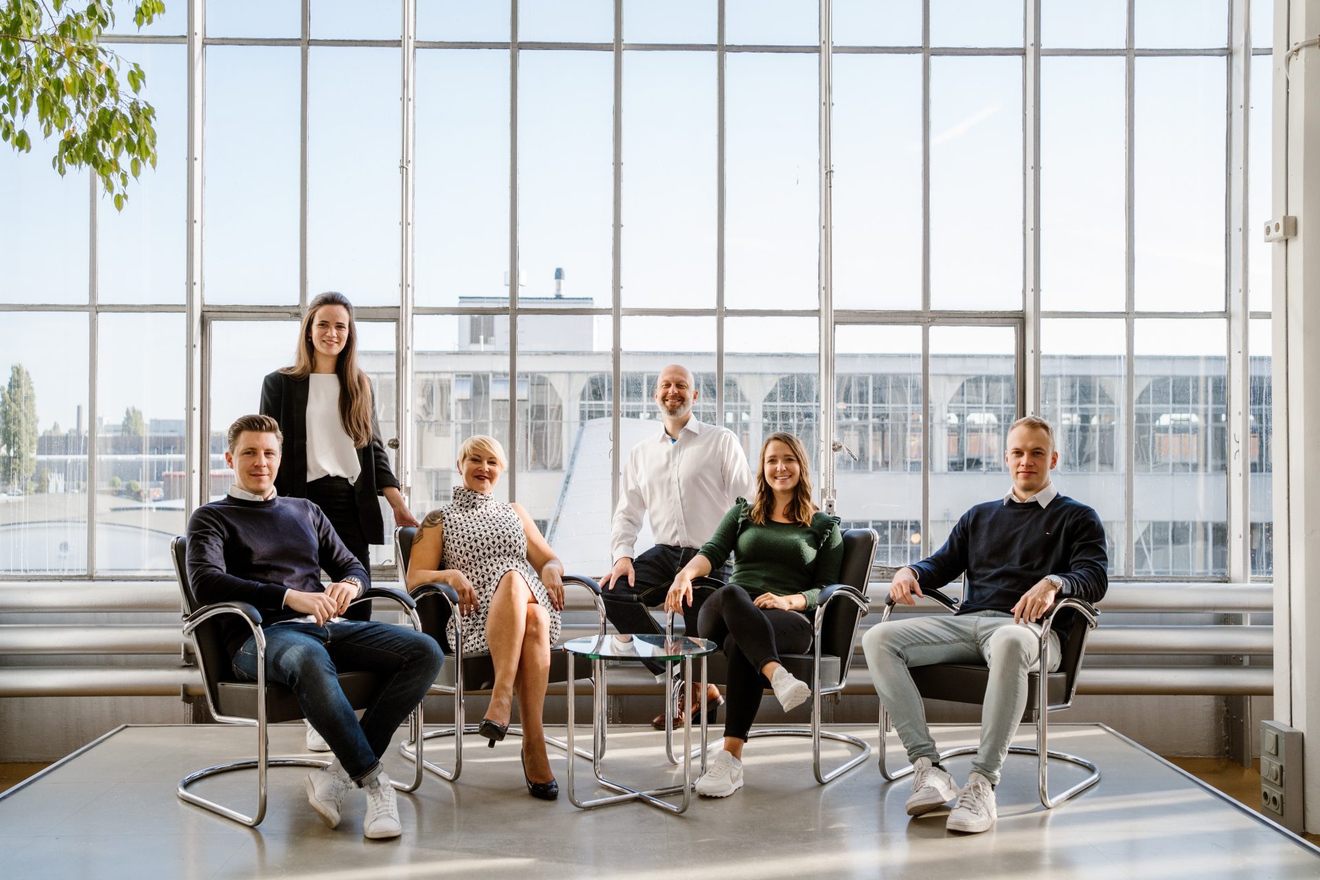 Teammitglieder sitzen vor Glasscheibe im Büro