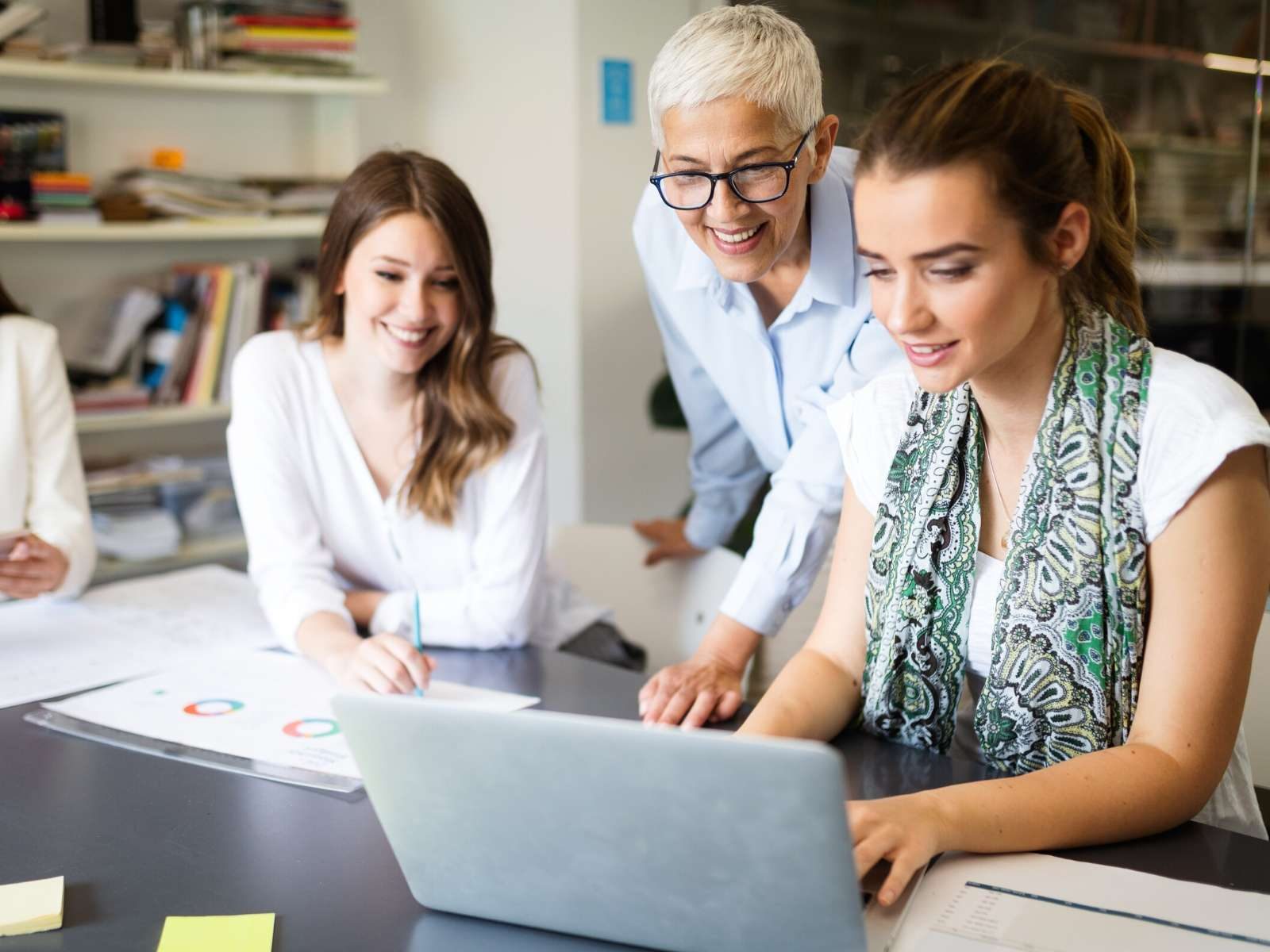 three women looking at a computer and evaluating business choices